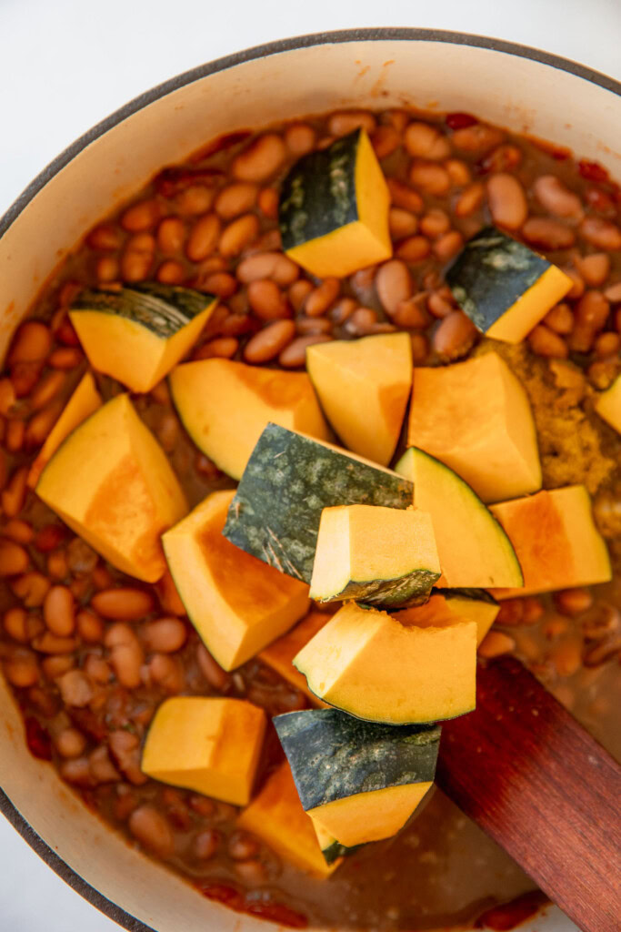 Adding the beans and squash to the pot of sofrito.