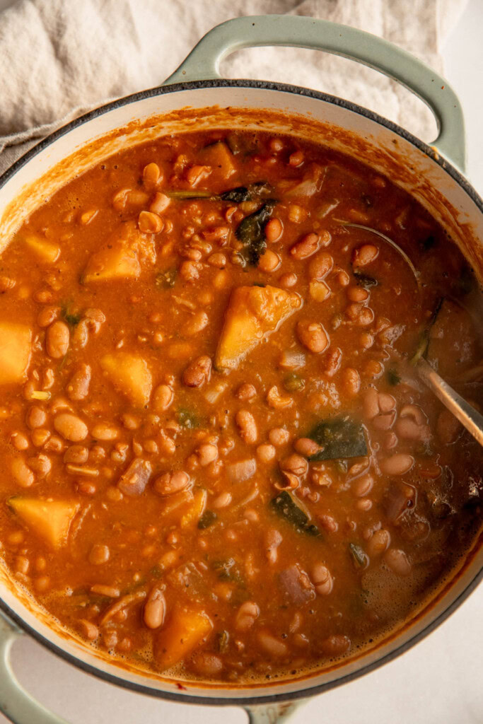 Cooked stewed beans in a large pot.