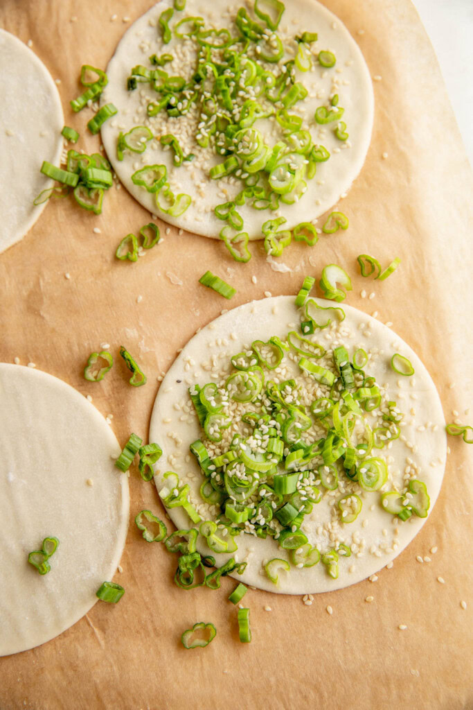 The cut puff pastry topped with scallions and sesame seeds.
