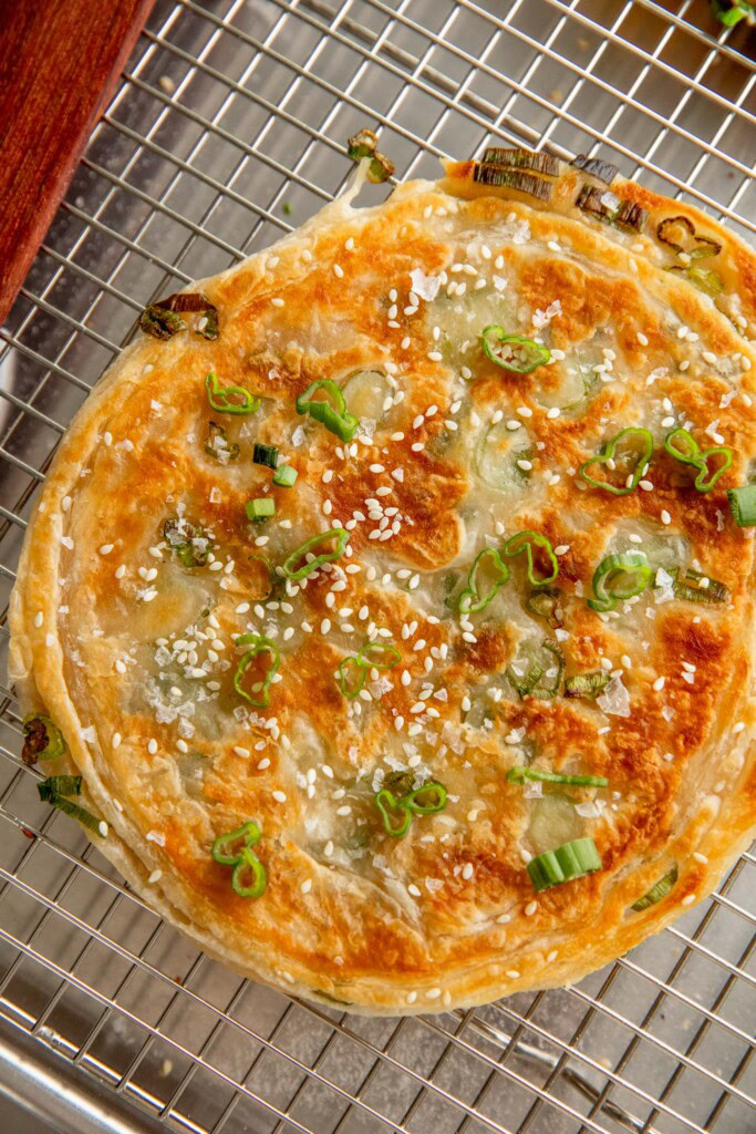 Cooked scallion pancake on a cooling rack.