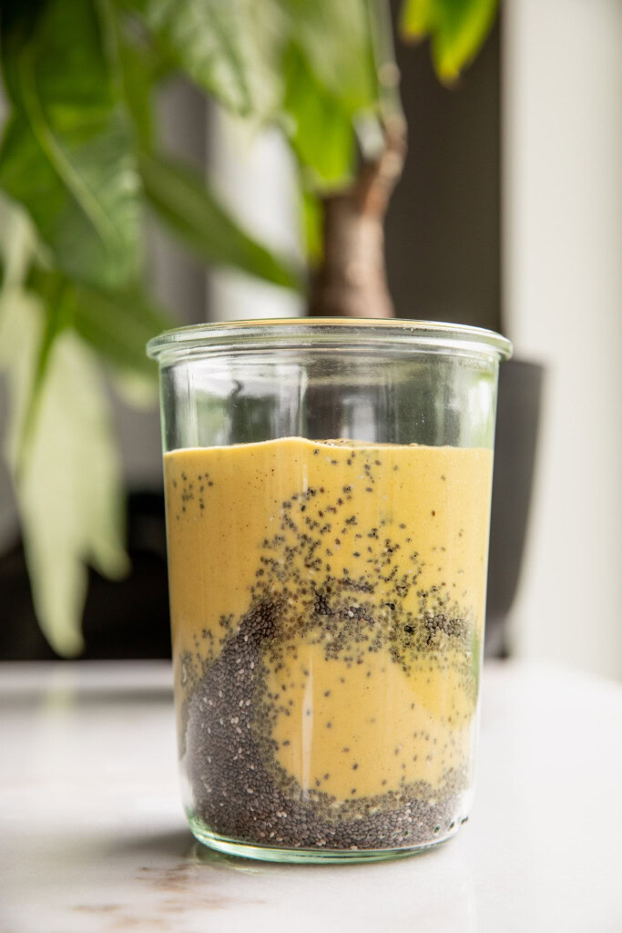 Adding the chia seeds and mango milk together in a jar.
