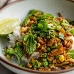 Mound of rice topped with sticky tempeh and scallion salad.