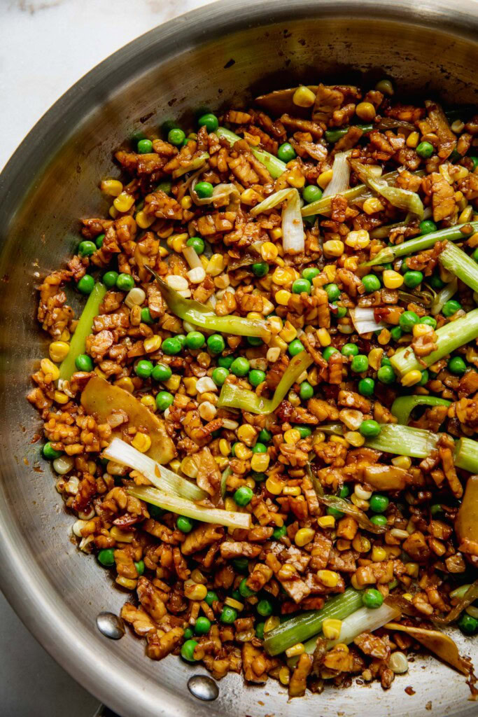 Caramelized tempeh and veggies in a pan.