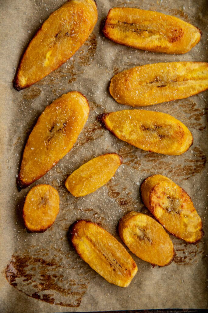 Baked plantain slices on a baking tray.