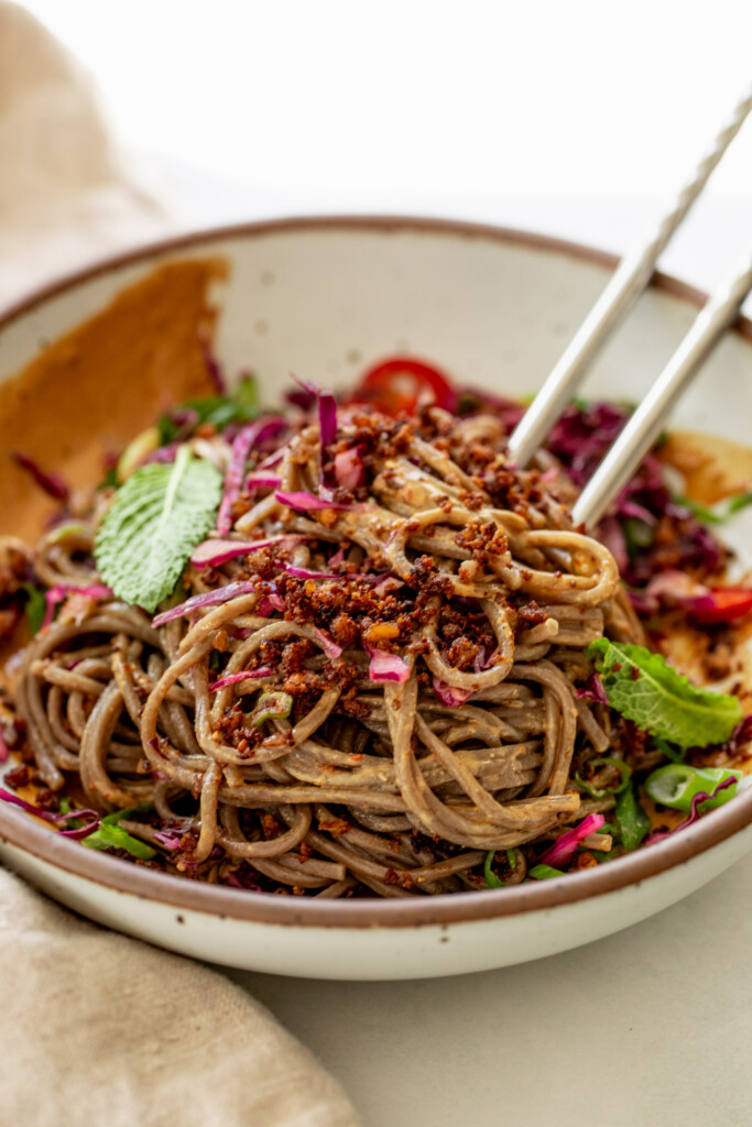 Noodles mixed with sesame dressing, cabbage, herbs, scallions, and tofu.