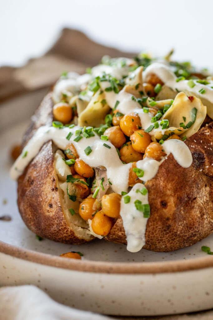 Chickpea and artichoke stuffed potato drizzled with almond yogurt sauce.