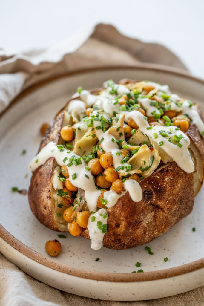 Stuffed baked potato drizzled with a yogurt almond sauce on top.