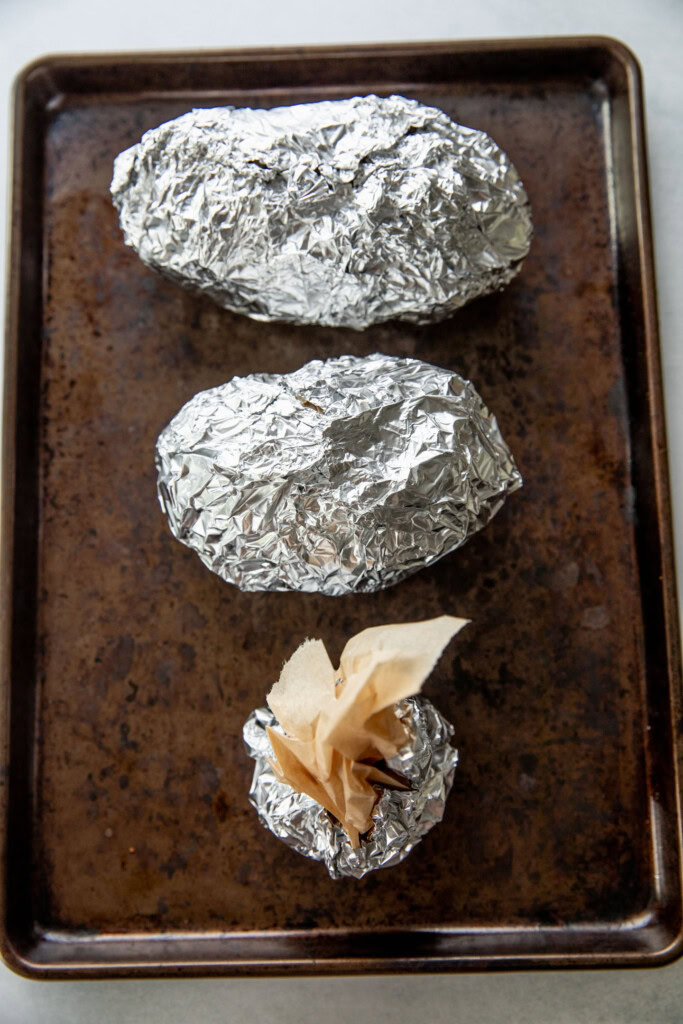 Wrapping the potatoes and garlic in foil to bake in the oven.