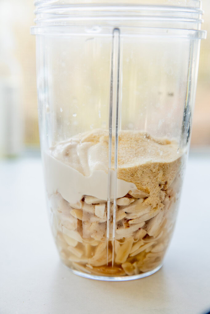 Adding the soaked almonds and yogurt together in a blender cup.