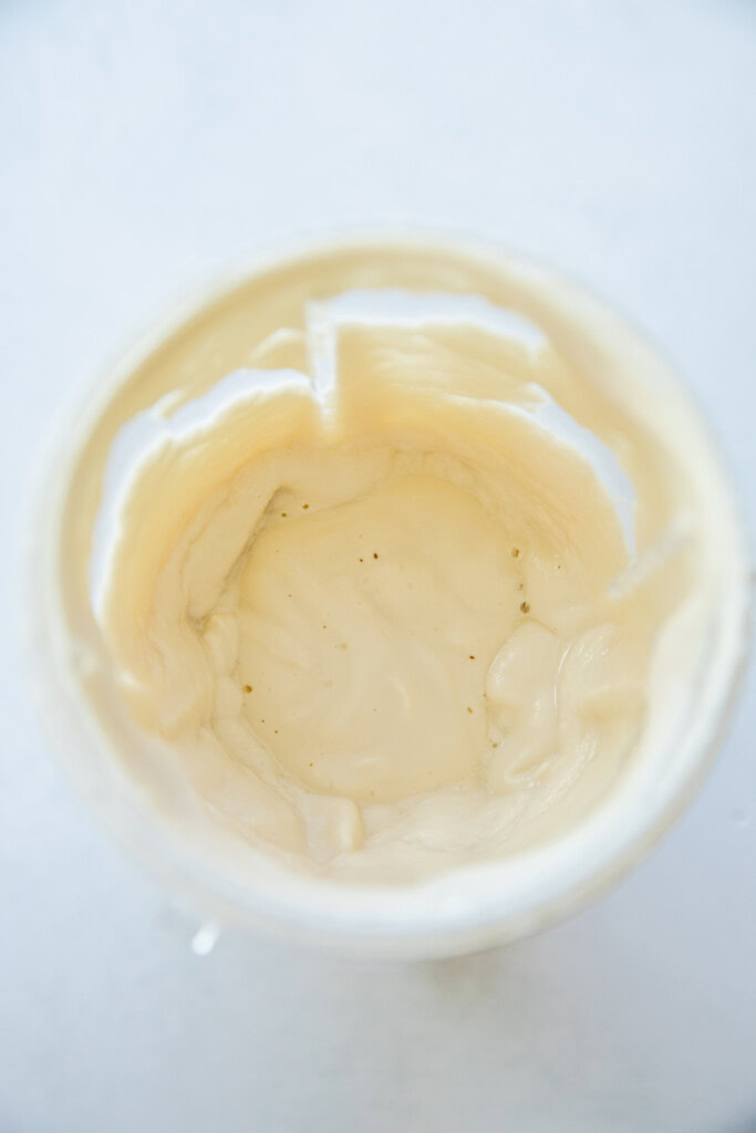 Blended almond sauce in a blender cup.