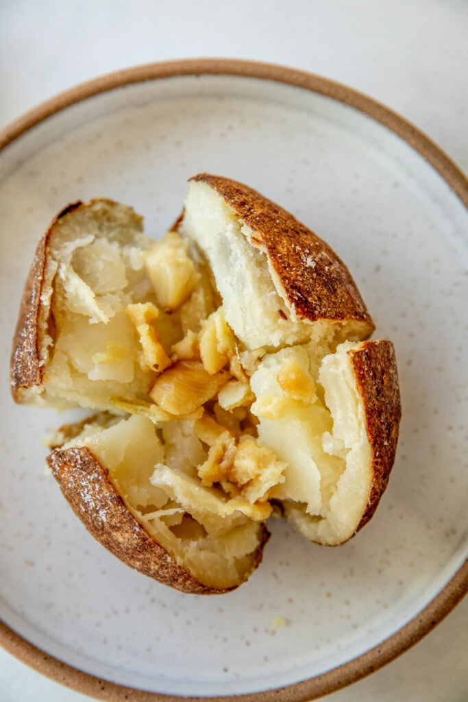 Potato cut in half and stuffed with roasted garlic cloves.
