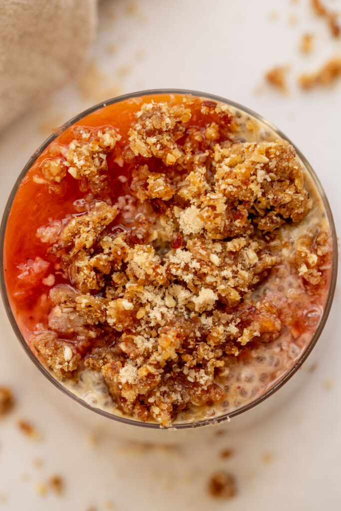Top down view of cooked peaches and the crumb topping layered on top of chia pudding.