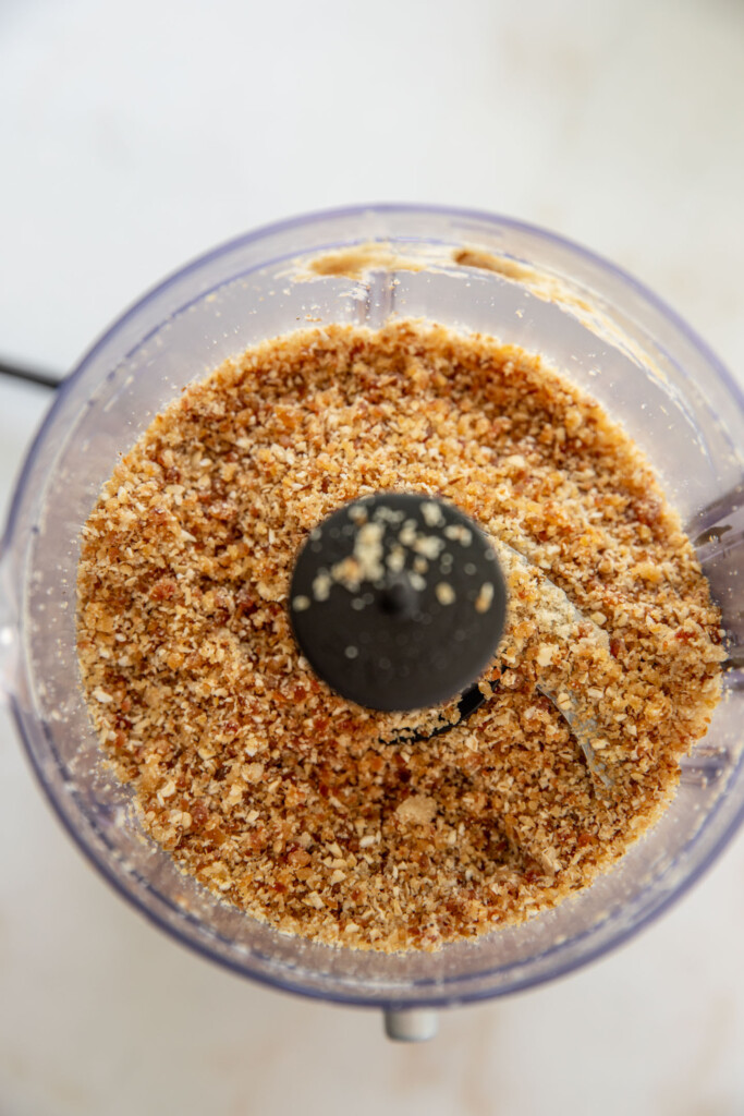 Fine date oat crumble in a food processor cup.