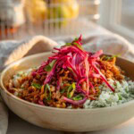 Side view of a bowl of high fiber rice topped with shredded tofu and pickled cabbage.