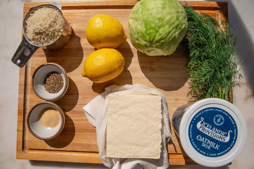 Cutting board with tofu, yogurt, lemon, cabbage, dill, seasonings, and panko.