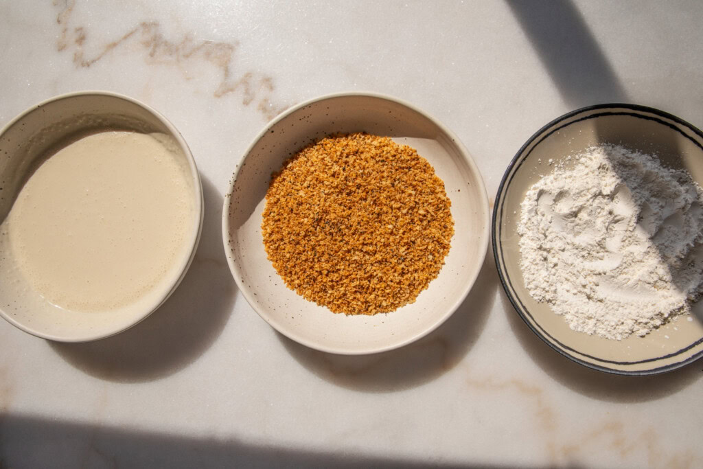 Three dredging stations, one bowl with cornstarch, one bowl with panko, and the last a buttermilk mixture.