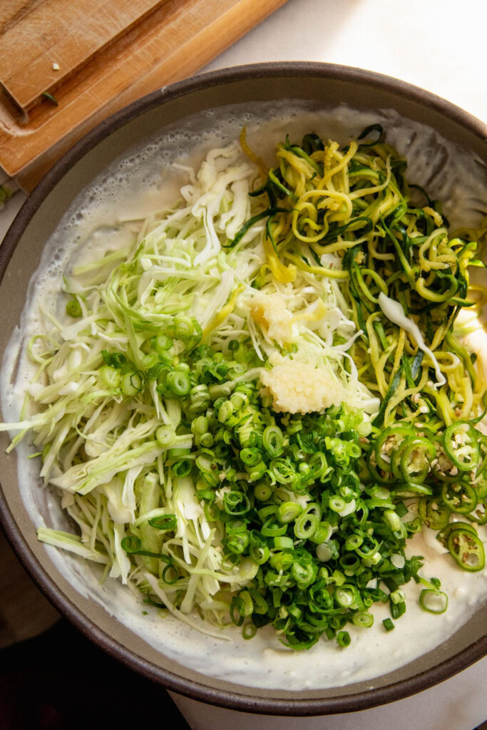 Mixing the shredded vegetables into the pancake batter.