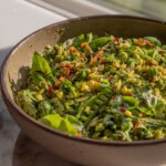 Large bowl filled with orzo pasta salad that is tossed in a creamy basil vinaigrette.