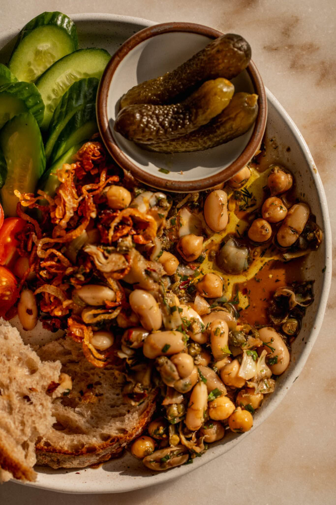 Plate of bean salad after scooping out of it to show the oil and vinegar dressing at the bottom.