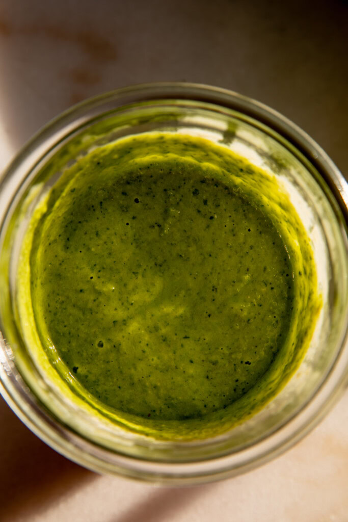 Blended basil vinaigrette in a jar.