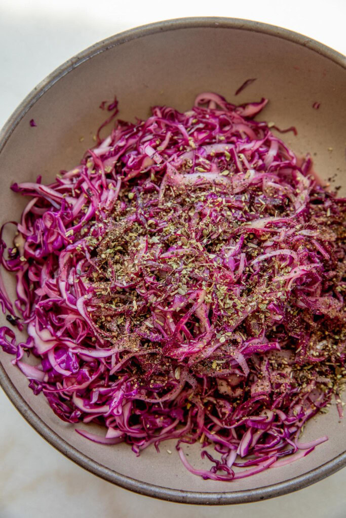 Added black pepper and oregano on top of the slaw mixture.