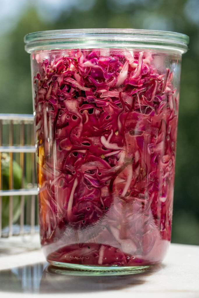 Storage container filled with slaw and the juice from the bottom of the bowl.