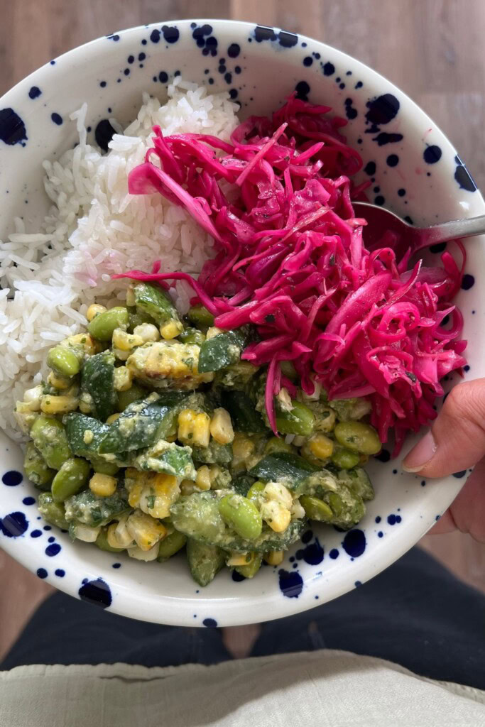 Bowl with edamame salad, red cabbage slaw and white rice.