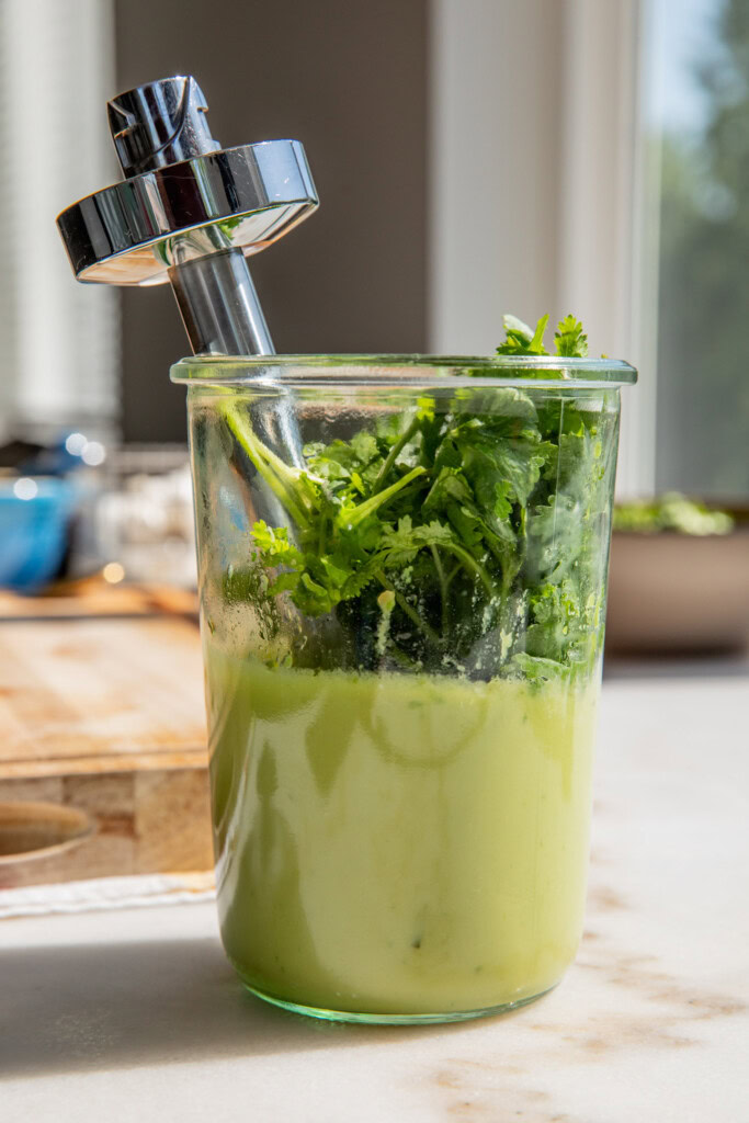 Blending the cilantro together with the creamy avocado sauce.