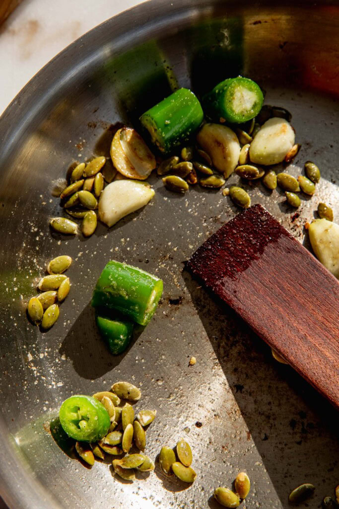 Pan with toasted pepitas, peppers, and garlic.