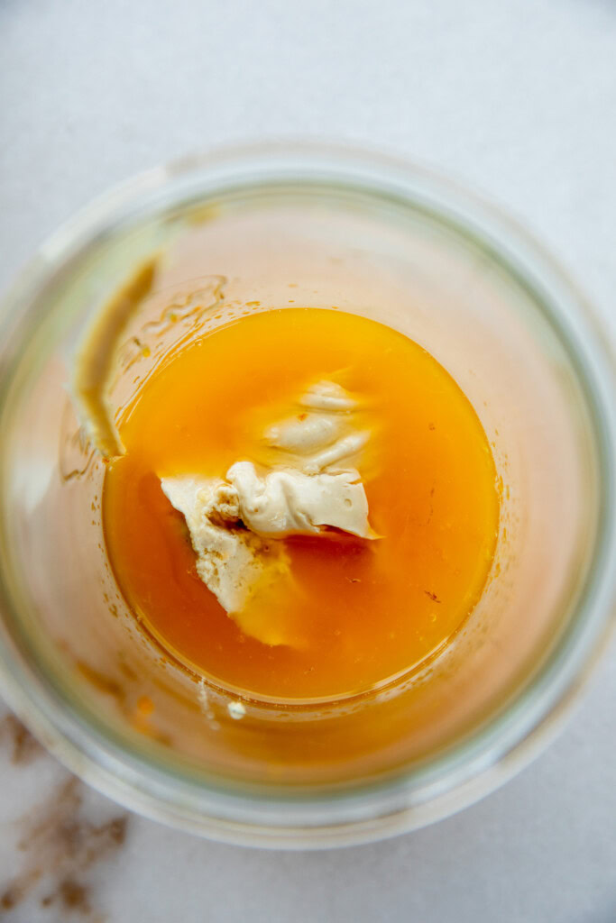 Adding the orange juice and yogurt in a blender cup.
