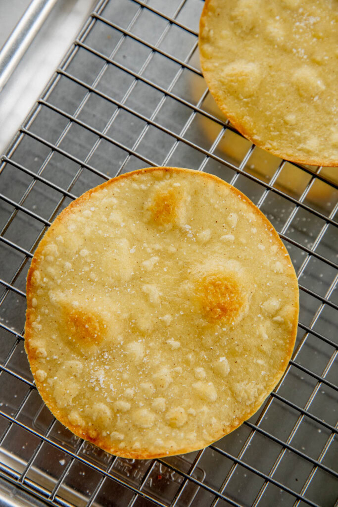 Baked crispy tostadas on a wire rack.