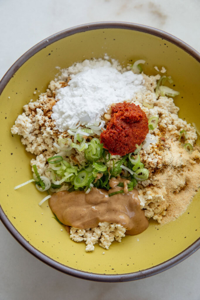 Bowl filled with tofu, curry paste, peanut butter, scallions, and potato starch.