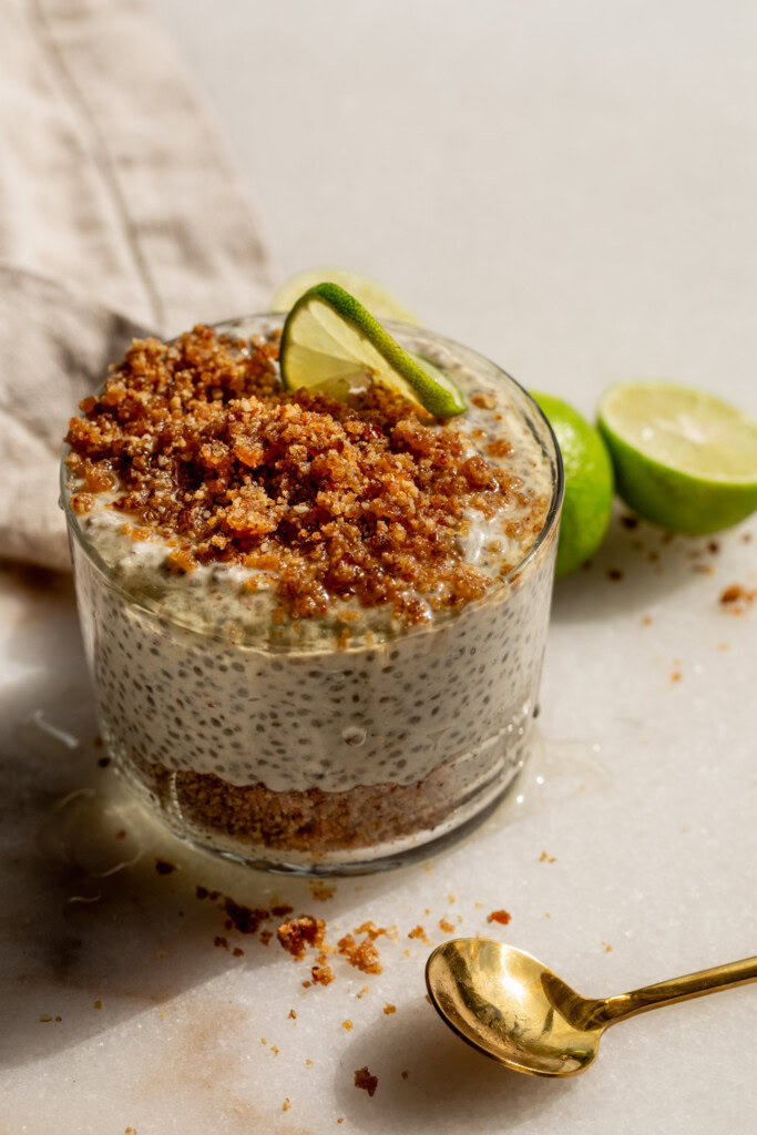 Jar of key lime cheesecake chia pudding in a jar layered with graham cracker crumb.