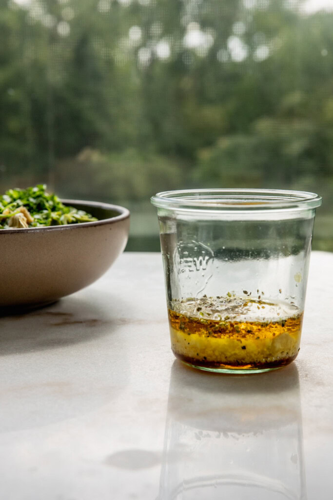 Jar filled with pepperoncini brine, vinegar, mustard, oil, and garlic.