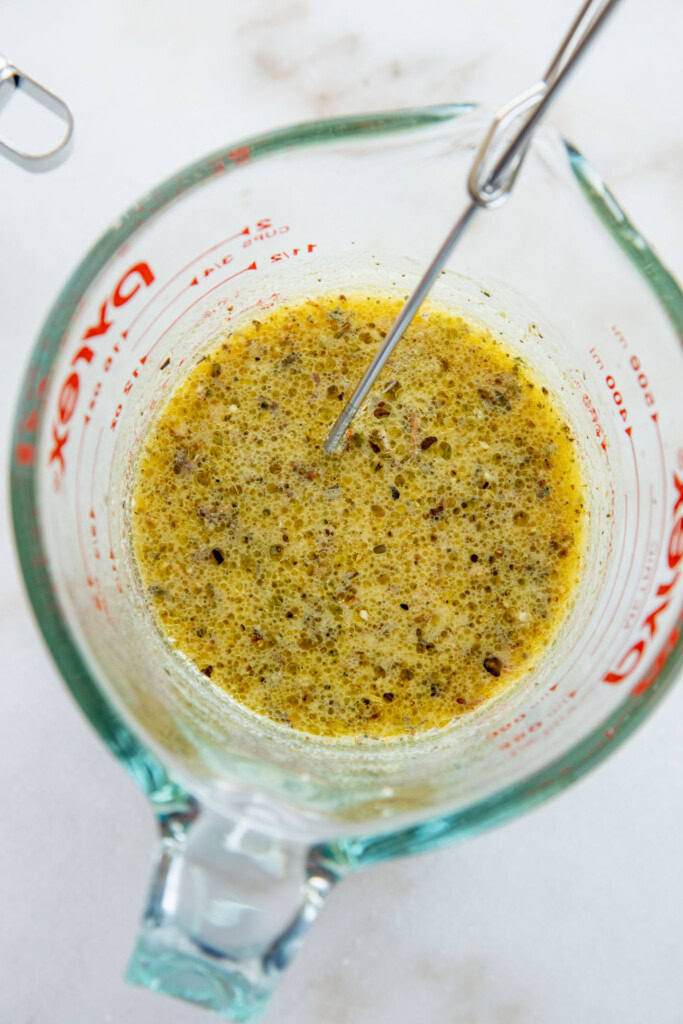 Whisking the marinade together in a large glass measuring cup.