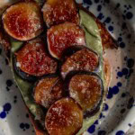 Plate of toast topped with pumpkin seed butter with caramelized fig slices on top.