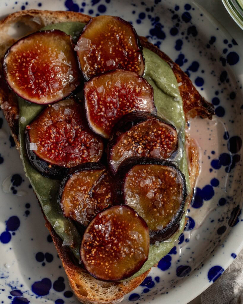 Plate of toast topped with pumpkin seed butter with caramelized fig slices on top.