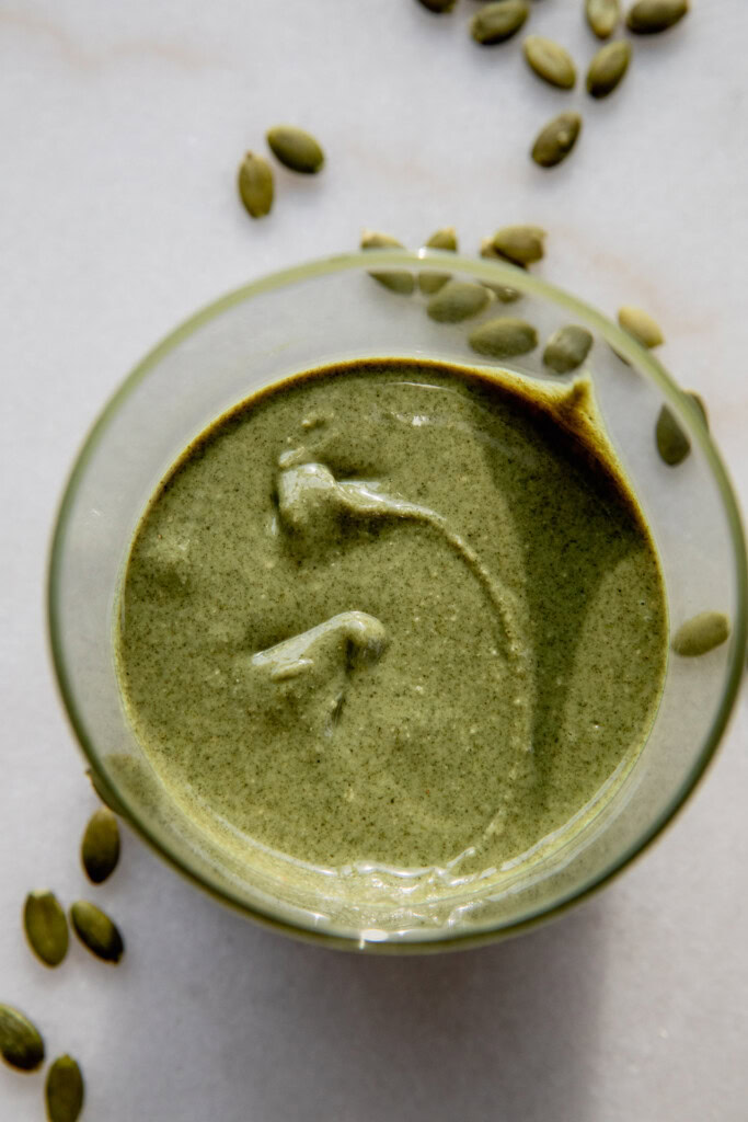 Placing the pumpkin seed butter in a container.