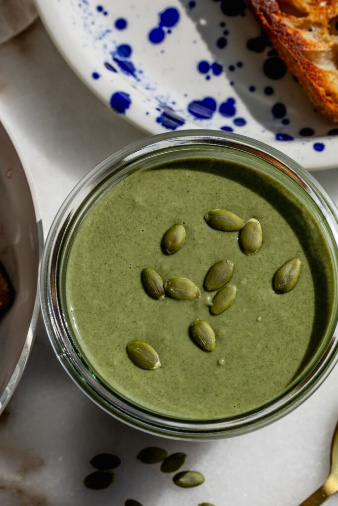 Pumpkin seed butter in a jar topped with a few pumpkin seeds.