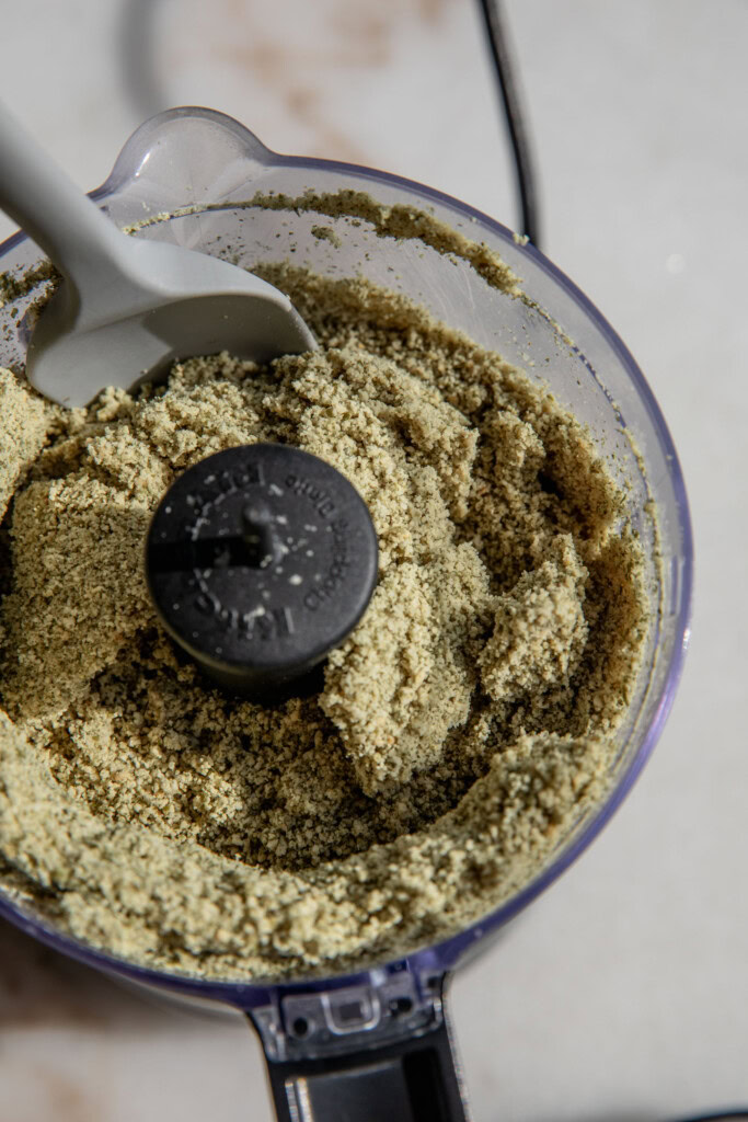 Scraping down pumpkin seeds pulverized into a fine crumb.