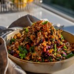 A bowl with roasted cabbage and carrot salad served in a bowl topped with crispy chickpeas and a hoisin peanut sauce.