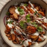 Tofu bowl mixed together with roasted potatoes, marinated onions and garlic sauce.