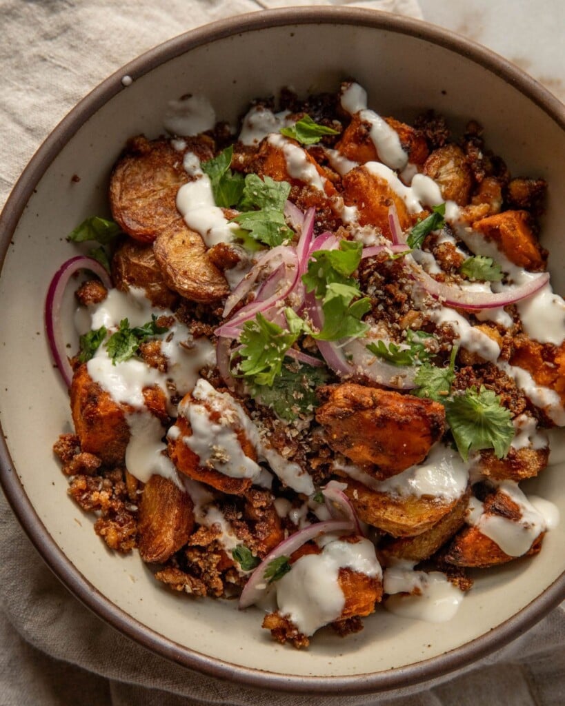 Tofu bowl mixed together with roasted potatoes, marinated onions and garlic sauce.