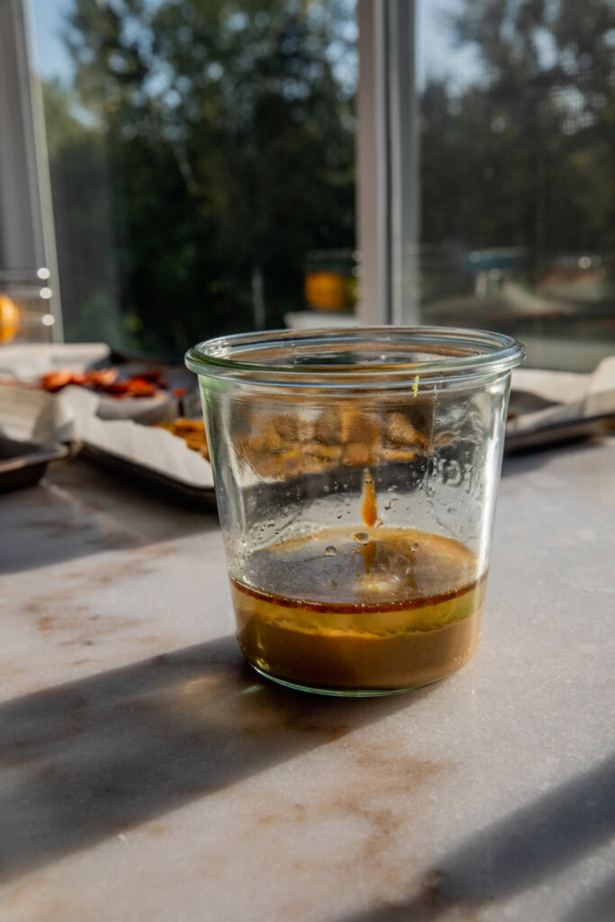 Peanut butter, hoisin sauce, lime juice, garlic, and sesame oil in a blender cup.