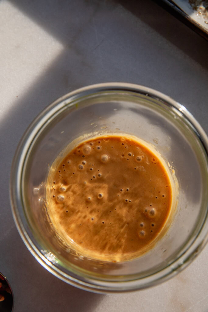 Blended creamy peanut hoisin sauce in a jar.