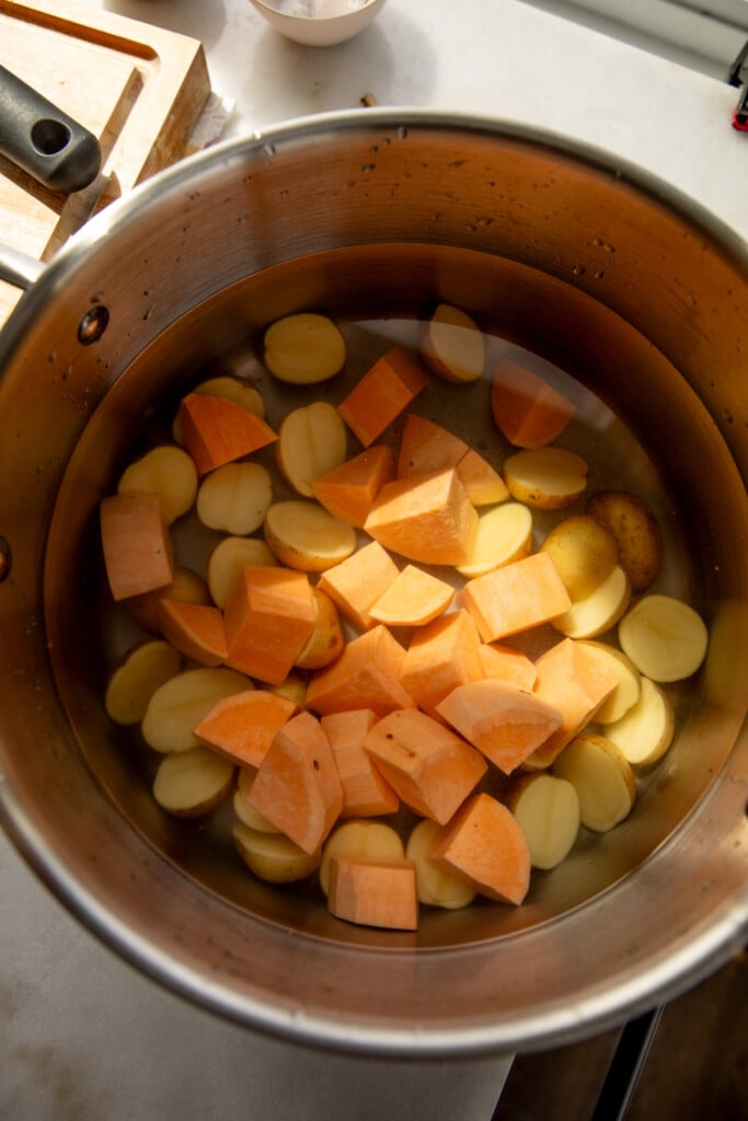 Pot filled with baby potatoes and cubed sweet potatoes.
