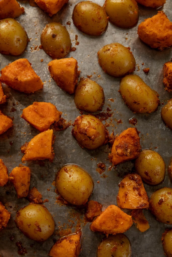 Roughed up potatoes on a baking tray.