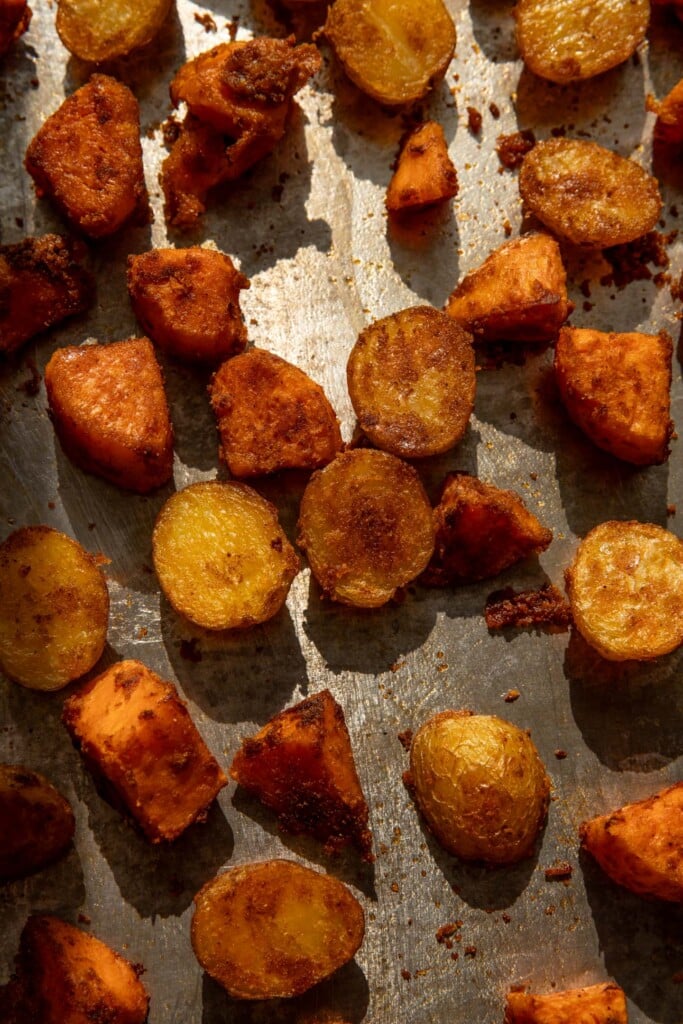 Roasted baked potatoes on a baking tray.